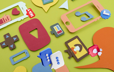 a colorful arrangement of cut-out icons representing various digital media and social platforms, including YouTube, messaging apps, and gaming controllers