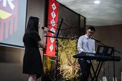 A student playing the piano while student sings